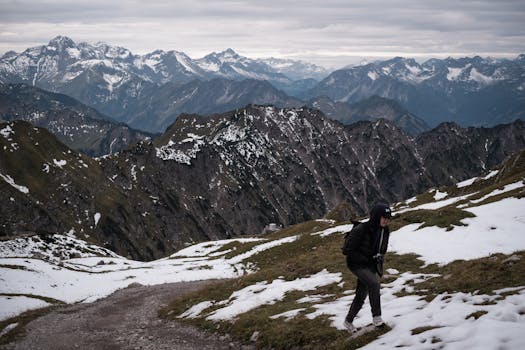 A person hiking in a stunning snowy mountain range during daytime.