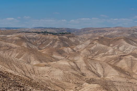 Breathtaking view of Israel's arid desert terrain with rolling hills under a clear sky.