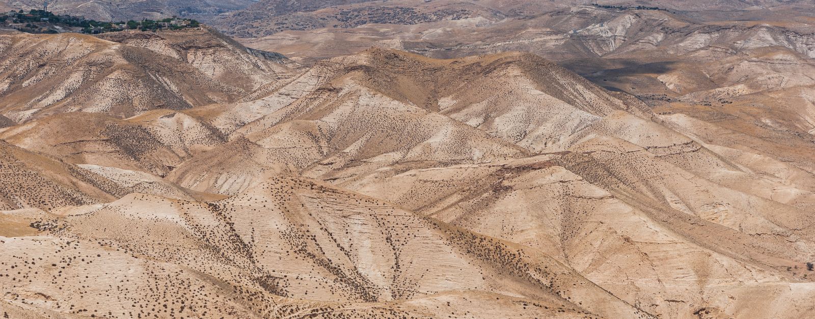 Scenic view of arid desert hills under a clear blue sky in Israel.