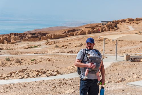 Free A father with a baby in a carrier explores the historic site of Masada in Israel. Stock Photo