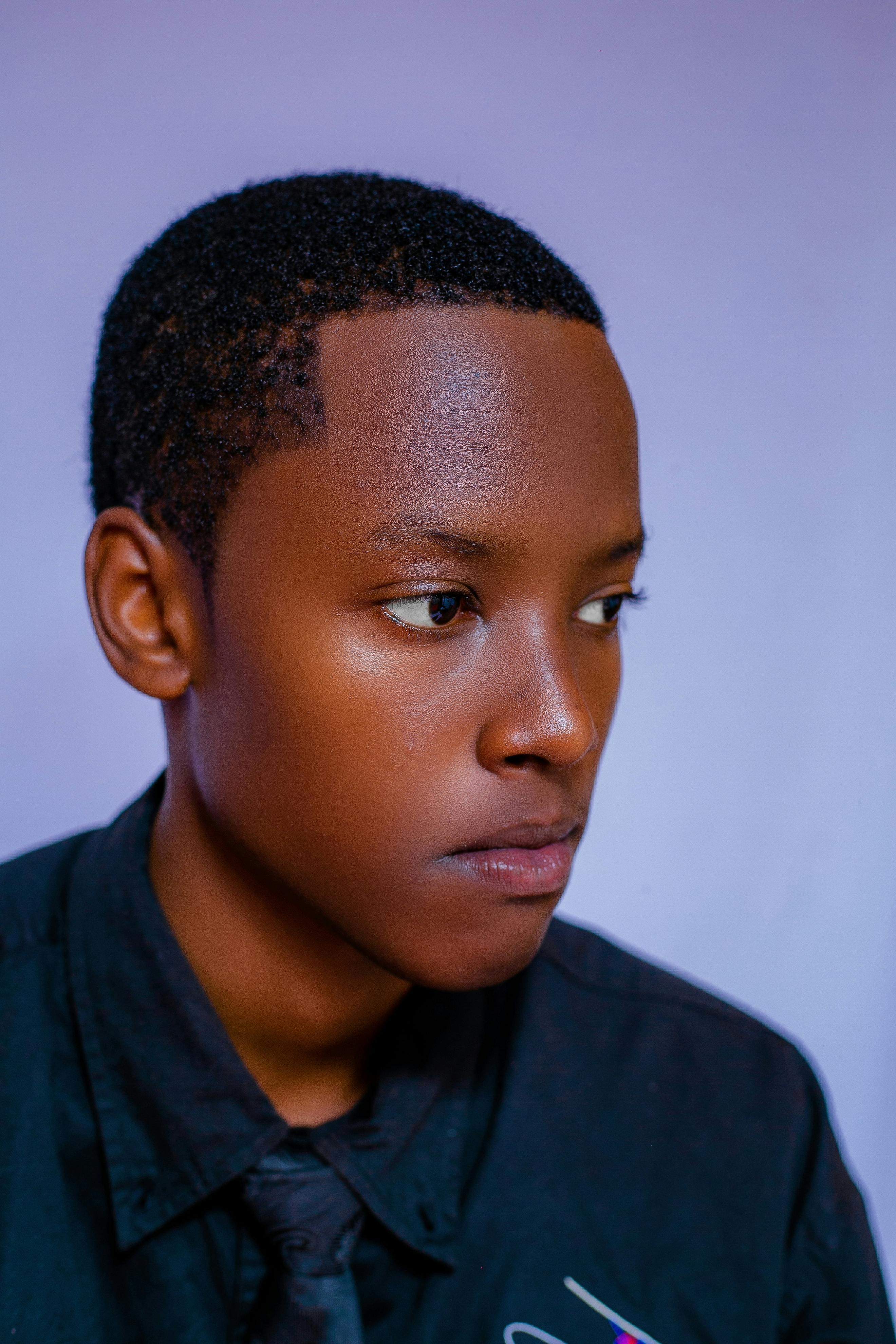 Close-up portrait of a young adult wearing a black shirt, looking thoughtful.