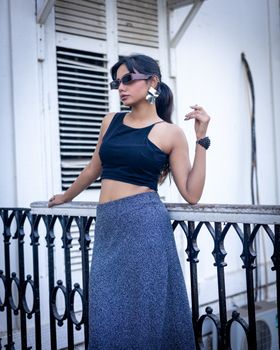 Stylish woman posing in urban setting wearing trendy fashion.
