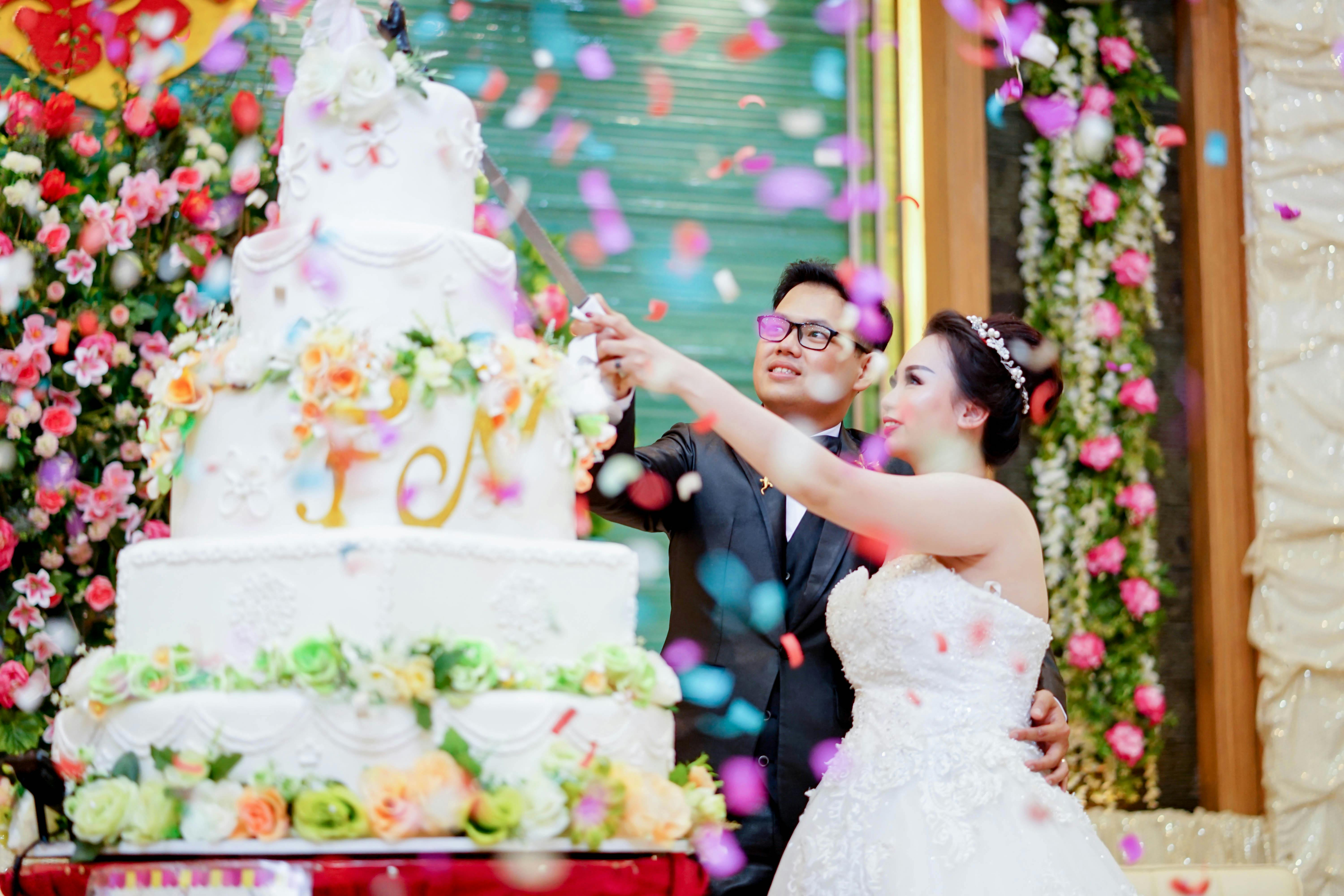 Bride And Groom Cutting A Huge 5-layered Wedding Cake