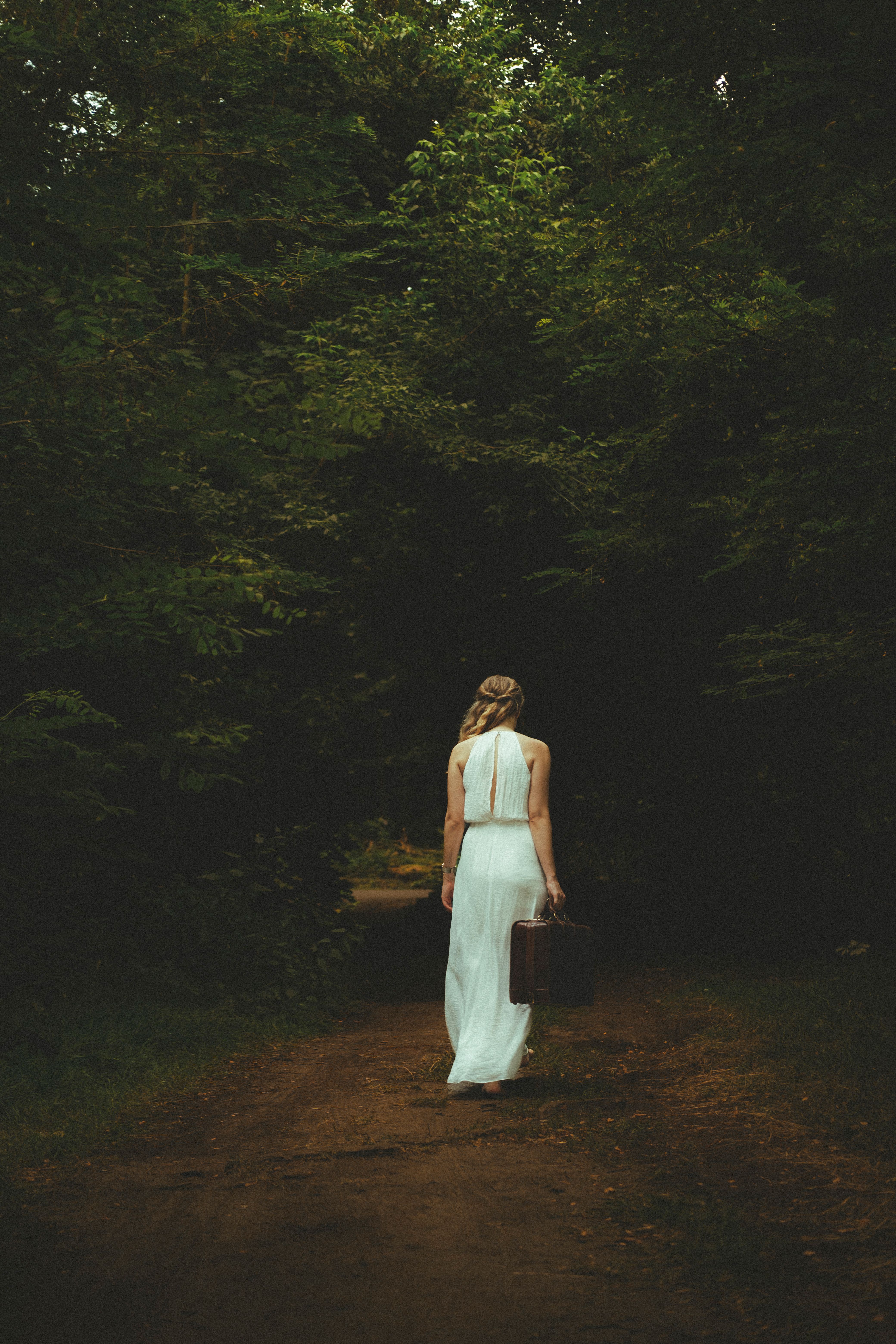 Solitary Woman Walking in a Forested Pathway · Free Stock Photo