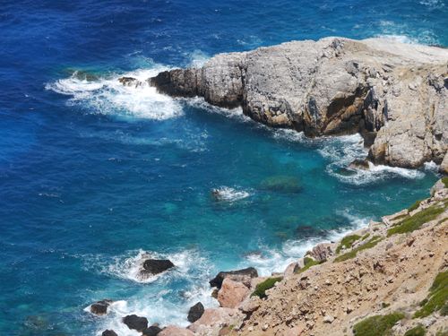 Free A breathtaking view of rugged coastline meeting vibrant turquoise waters under a clear blue sky. Stock Photo