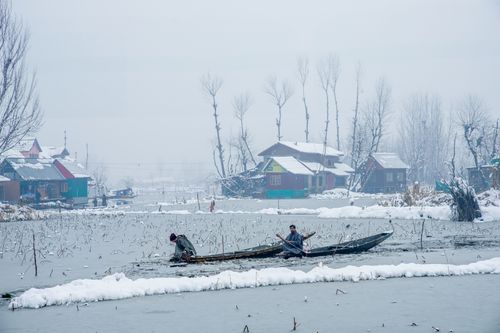 Free Two individuals paddle through snowy landscapes in Kashmir, showcasing the serene winter beauty. Stock Photo