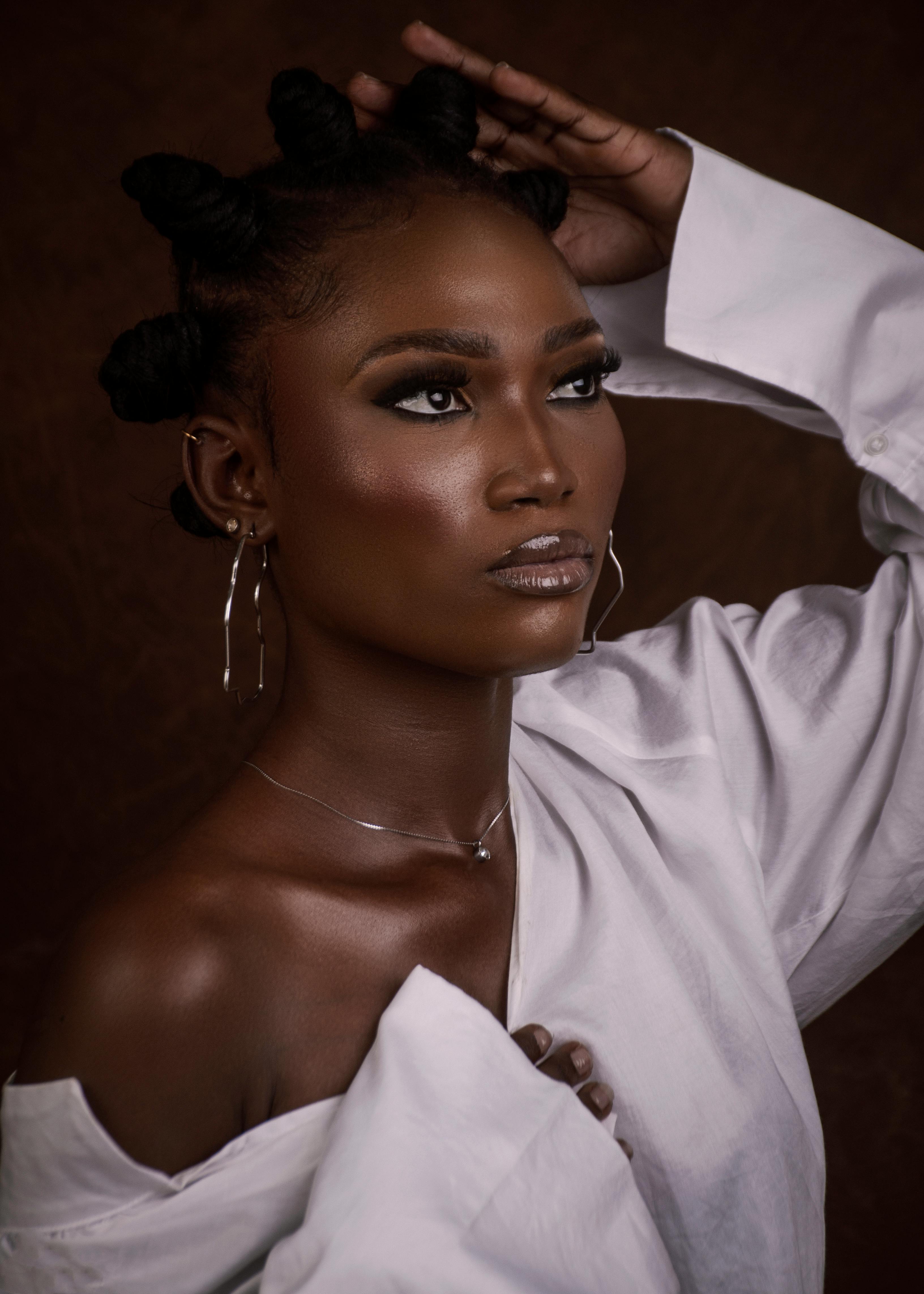 一个有着发髻、优雅珠宝和白色衬衫的女人的引人注目的肖像