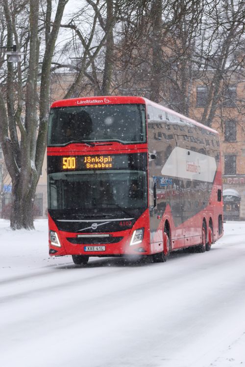 Free A red double-decker bus travels a snow-covered street in Jönköping, Sweden during winter. Stock Photo