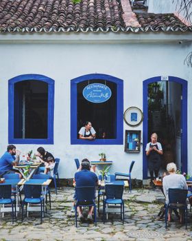Cozy outdoor dining at a charming restaurant with blue decor and cobblestone patio.