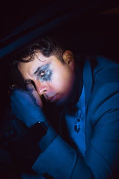 Emotional portrait of a man in a suit with dramatic lighting and smudged makeup.