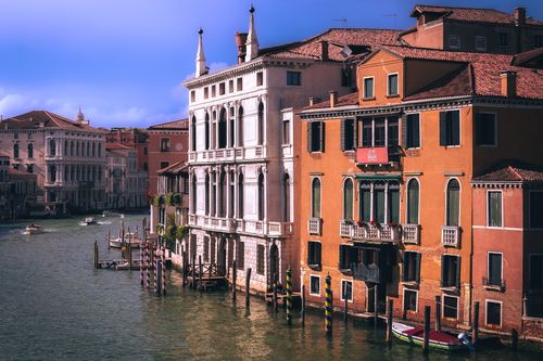 Free A scenic view of colorful historic buildings along a Venetian canal. Stock Photo