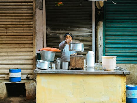 A street vendor cooks food at a vibrant urban market, showcasing local culinary traditions.
