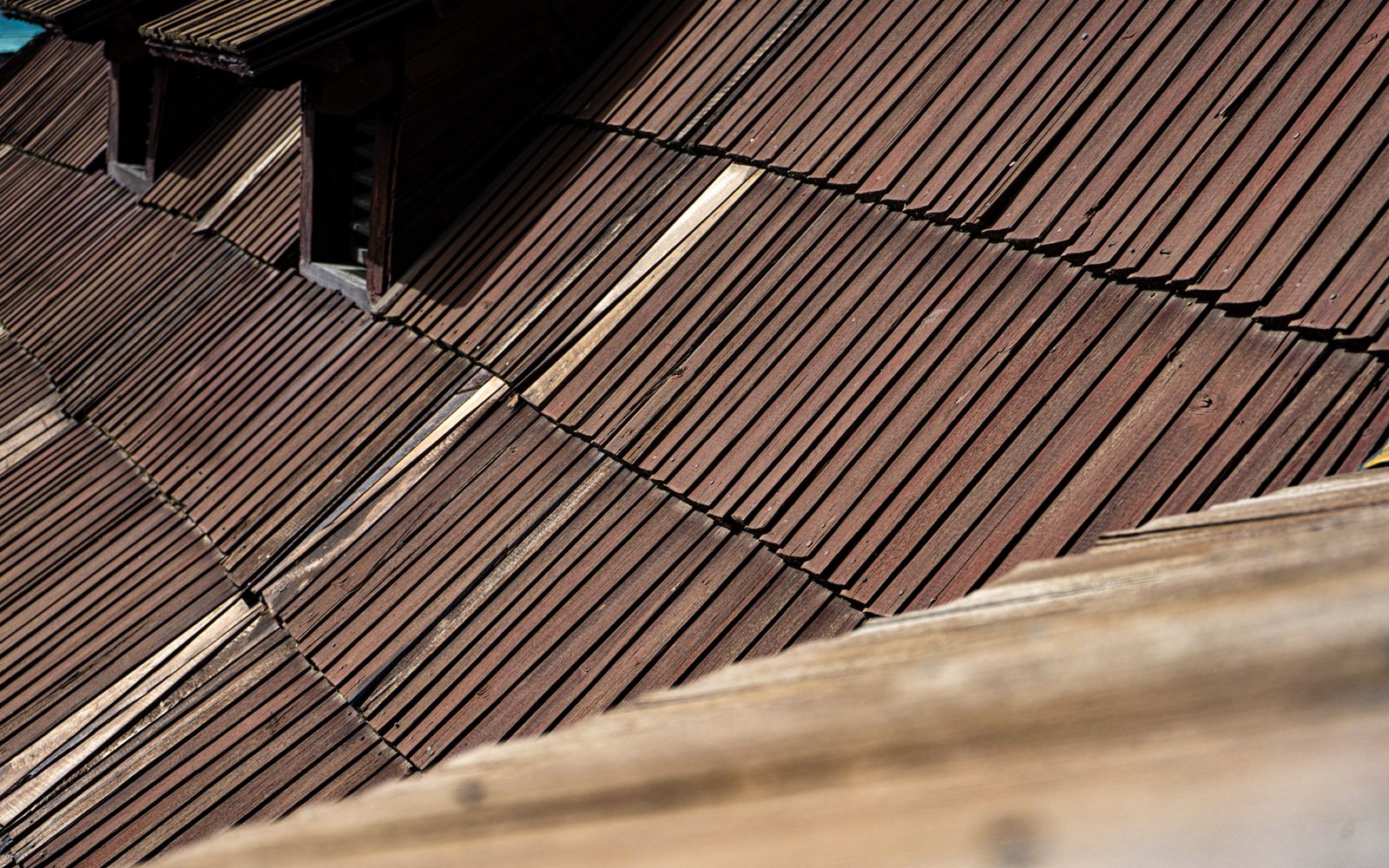 A close-up of rustic wooden roof shingles