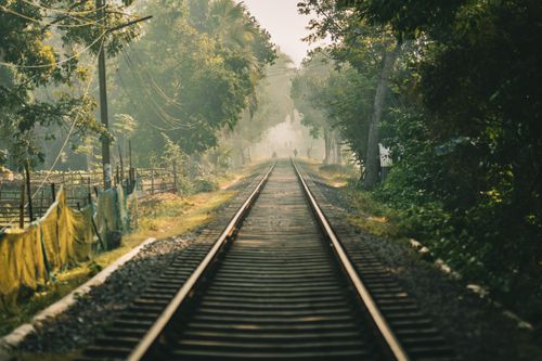 Free Serene view of railway tracks through lush greenery in Bangladesh, capturing morning mist. Stock Photo