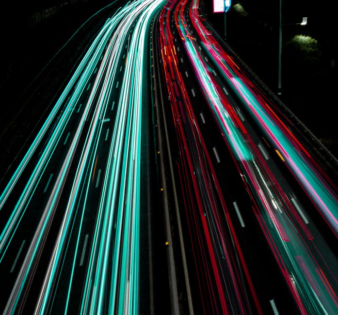 Long exposure photo capturing vibrant light trails on a highway at night. Long exposure photo capturing vibrant light trails on a highway at night.
