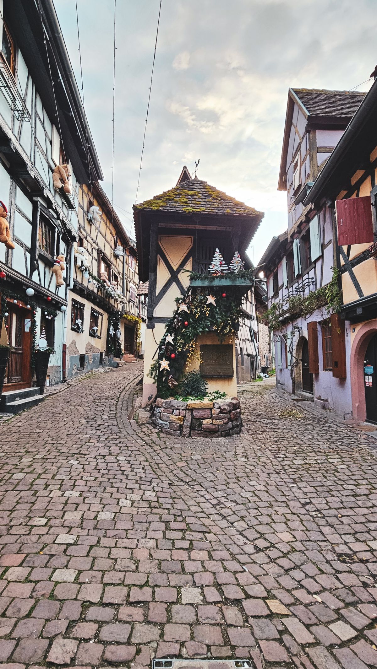A Christmas-decorated stone well in Eguisheim