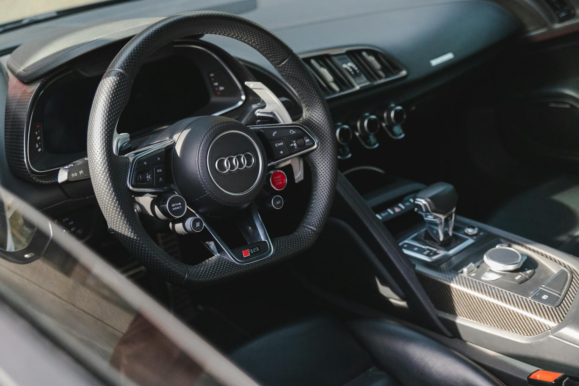 High-resolution image showcasing the sleek interior of a luxury Audi car, focusing on the steering wheel and dashboard.