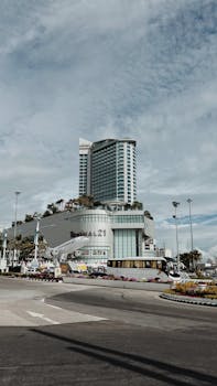 Modern architecture of Terminal 21 with urban landscape under a cloudy sky.