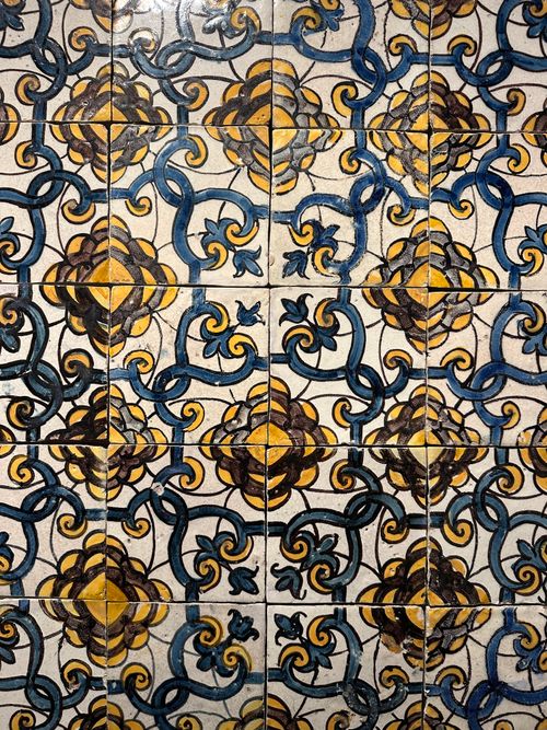 Free Detailed close-up of traditional Portuguese azulejo tiles with intricate blue and yellow patterns. Stock Photo