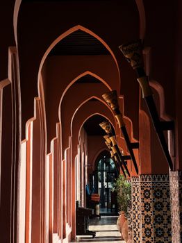 A mesmerizing view of a Moroccan style corridor with intricate arch designs and natural light.
