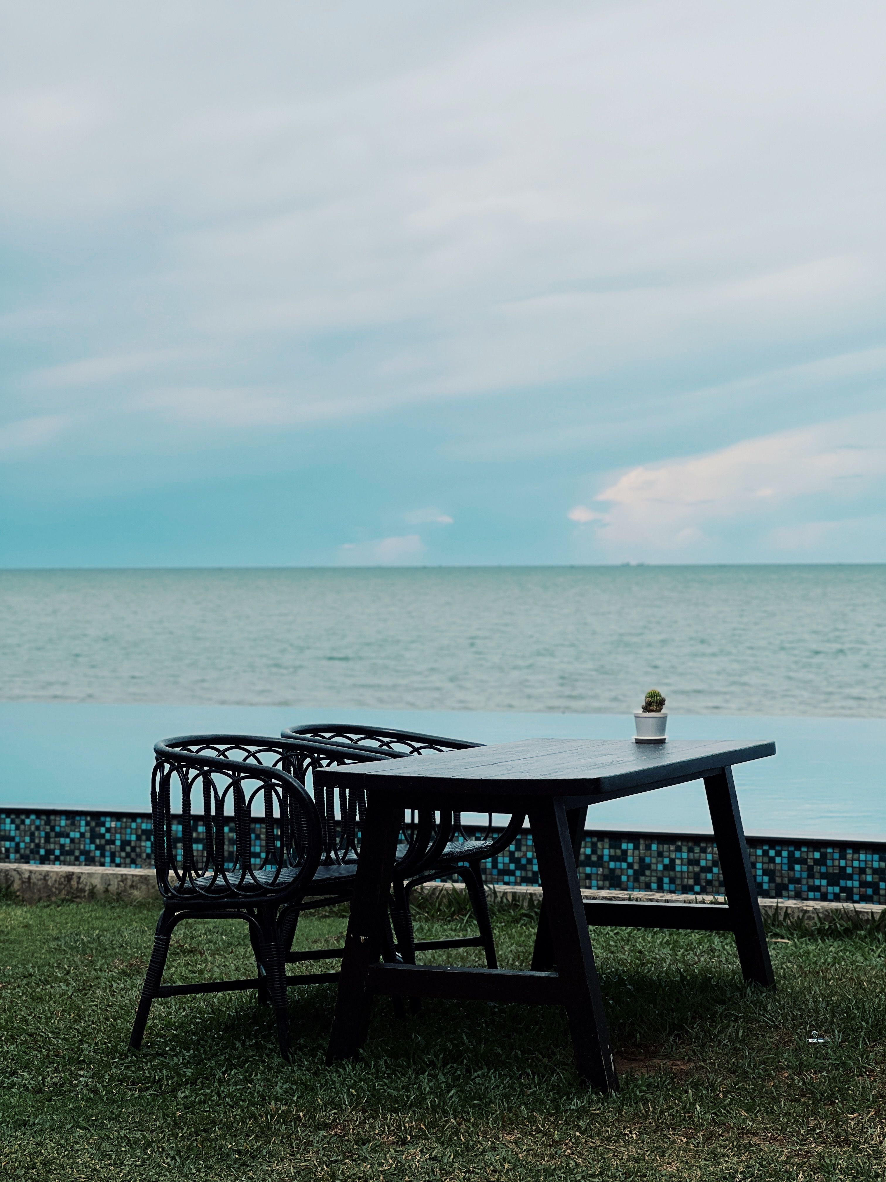 Serene Oceanfront Dining with Empty Table and Chairs · Free Stock Photo