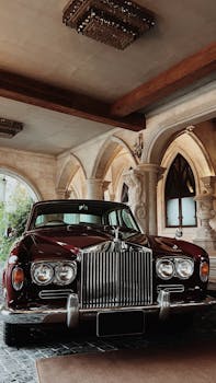 Classic Rolls Royce car parked in a lavish arched passageway, showcasing luxury and elegance.
