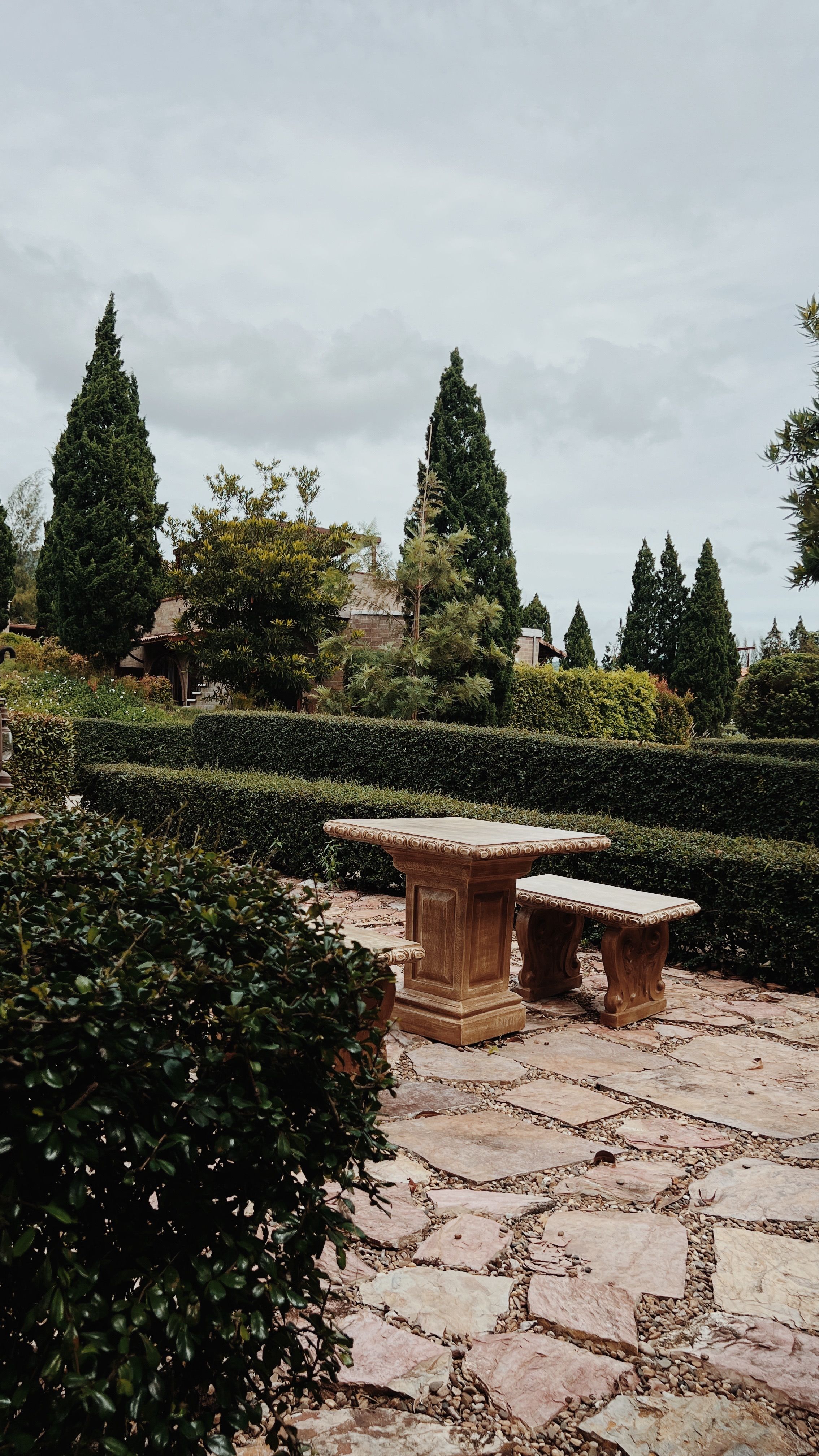 Serene Garden with Stone Table and Lush Greenery · Free Stock Photo