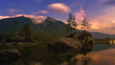 日出时分，宁静的山间湖泊映出岩石岛屿，色彩鲜艳