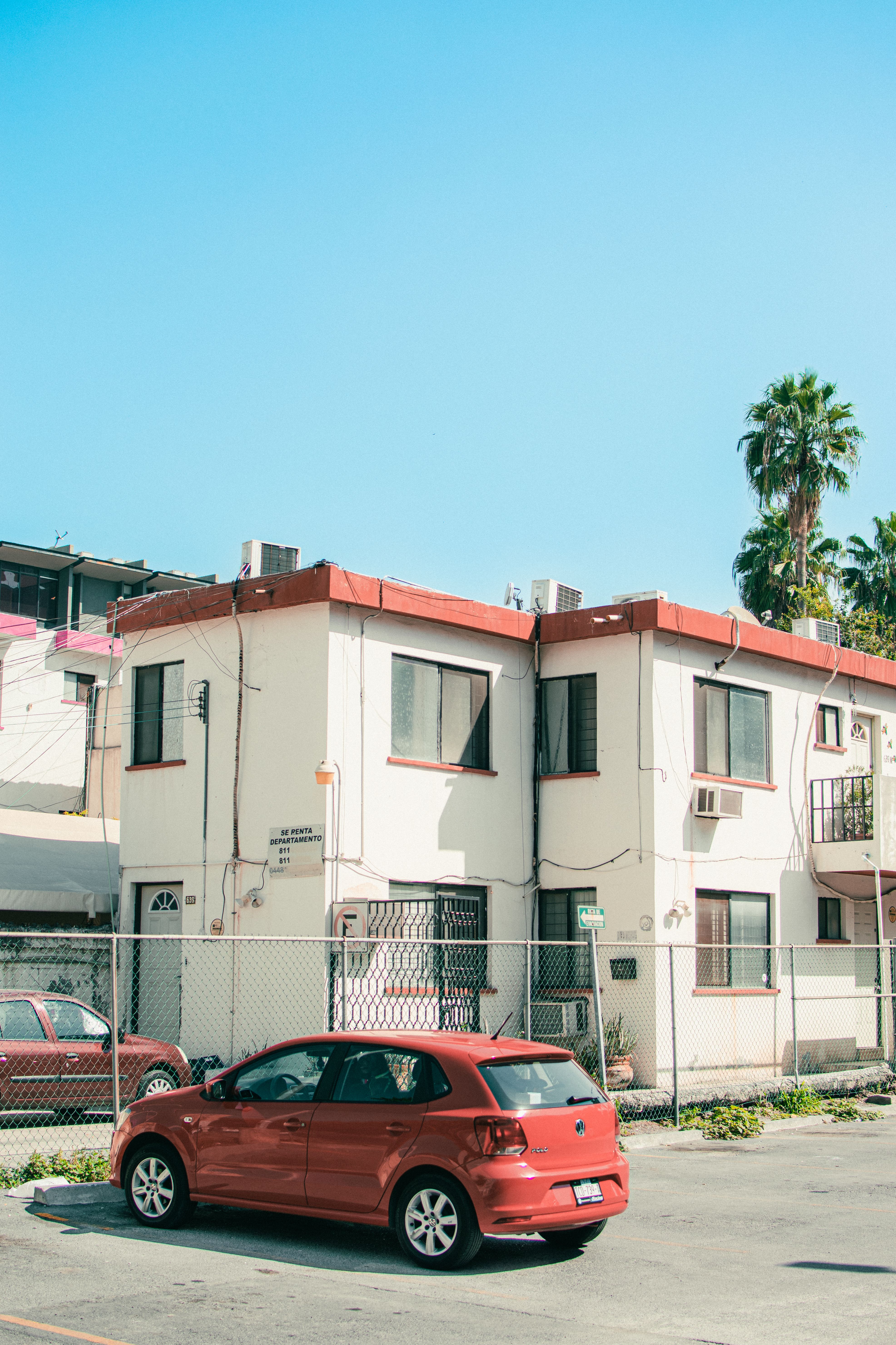 Red Car Parked in Front of Vintage Building · Free Stock Photo