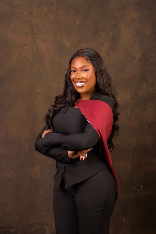 Free A joyful graduate in formal attire, exuding confidence against a dark, textured backdrop. Stock Photo