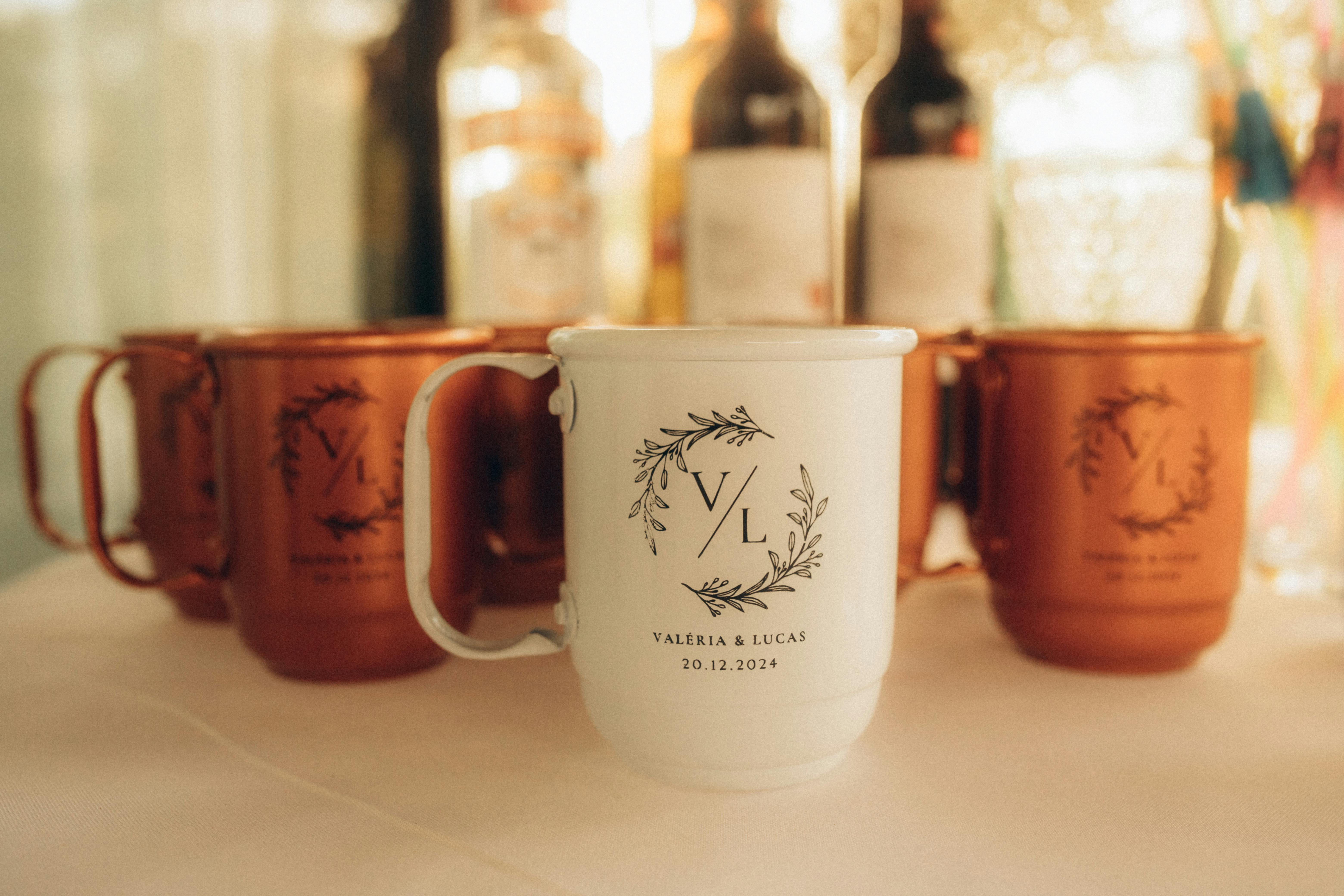 Custom white and bronze wedding mugs featuring initials and date, perfect for festive celebrations.