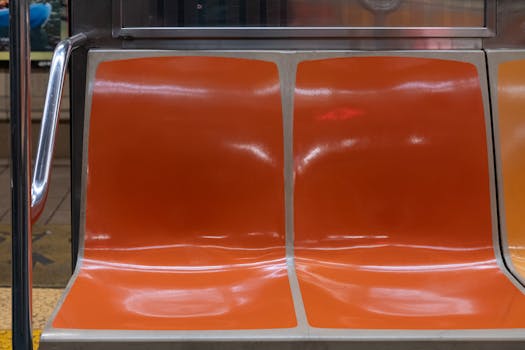 A close-up of empty orange seats in a New York City subway carriage.
