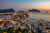 在港口上空令人惊叹的日落映衬下，探索挪威勒松令人惊叹的天际线