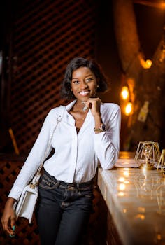 一位穿着优雅的时尚年轻女子在夜晚的室内微笑着