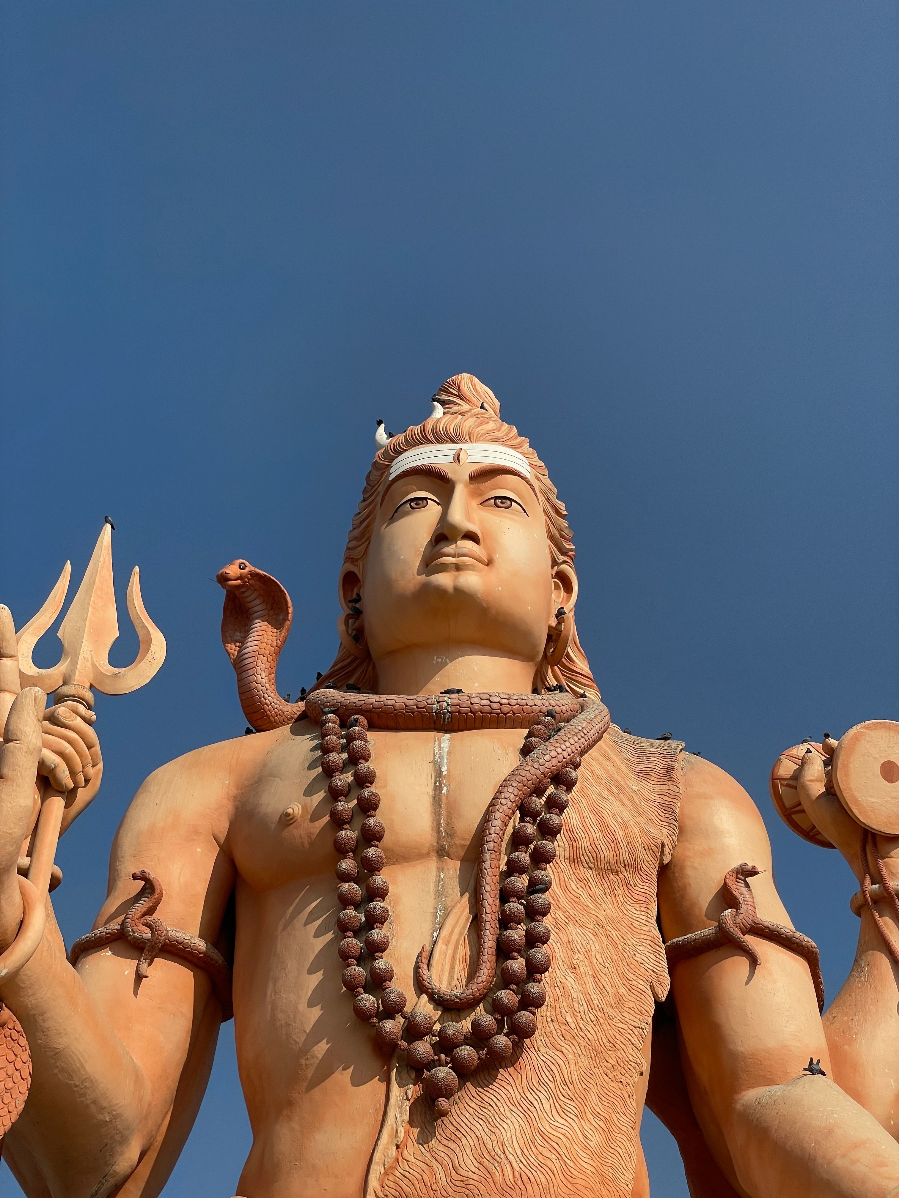 Close-up of the colossal Shiva statue in Nageshvar, Gujarat, India against clear blue sky.