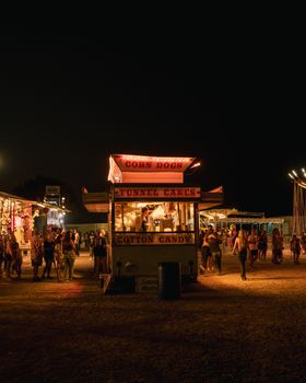 Lively night scene at a carnival in Council Bluffs, featuring food stalls and visitors.