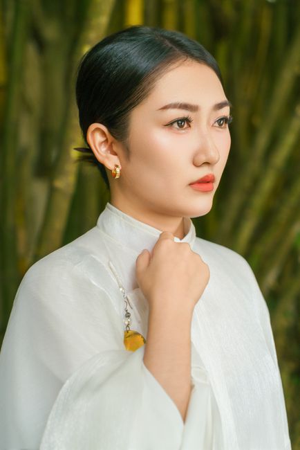 Kê Vàng: Khám phá công dụng, cách dùng và lợi ích tuyệt vời cho sức khỏe từ hạt ngũ cốc. 1 A serene portrait of a woman in traditional Vietnamese attire with bamboo background.