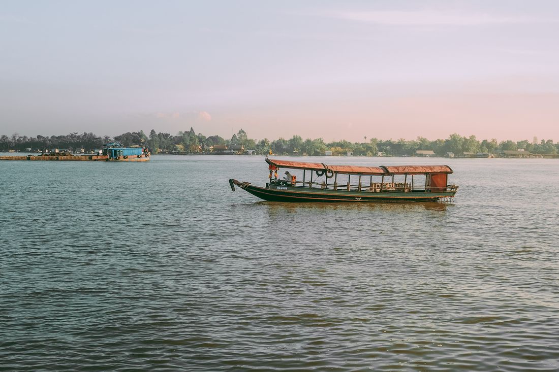 Traditional wooden boat on the Mekong River at sunset