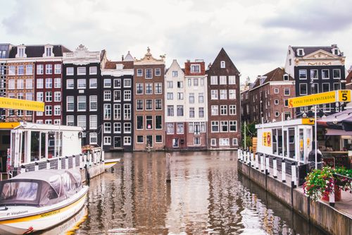 Free Explore Amsterdam's iconic canal view with historic homes and vibrant reflections. Stock Photo