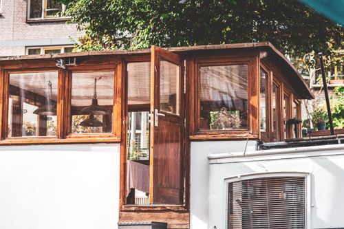 Free A cozy wooden houseboat with open door, surrounded by greenery, offering a serene lifestyle. Stock Photo