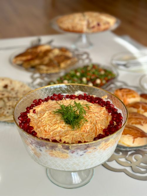 Free A beautifully arranged table featuring a pomegranate salad centerpiece and a variety of baked goods. Stock Photo
