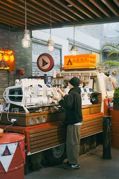 A stylish coffee shop truck with espresso machines serving drinks to customers.