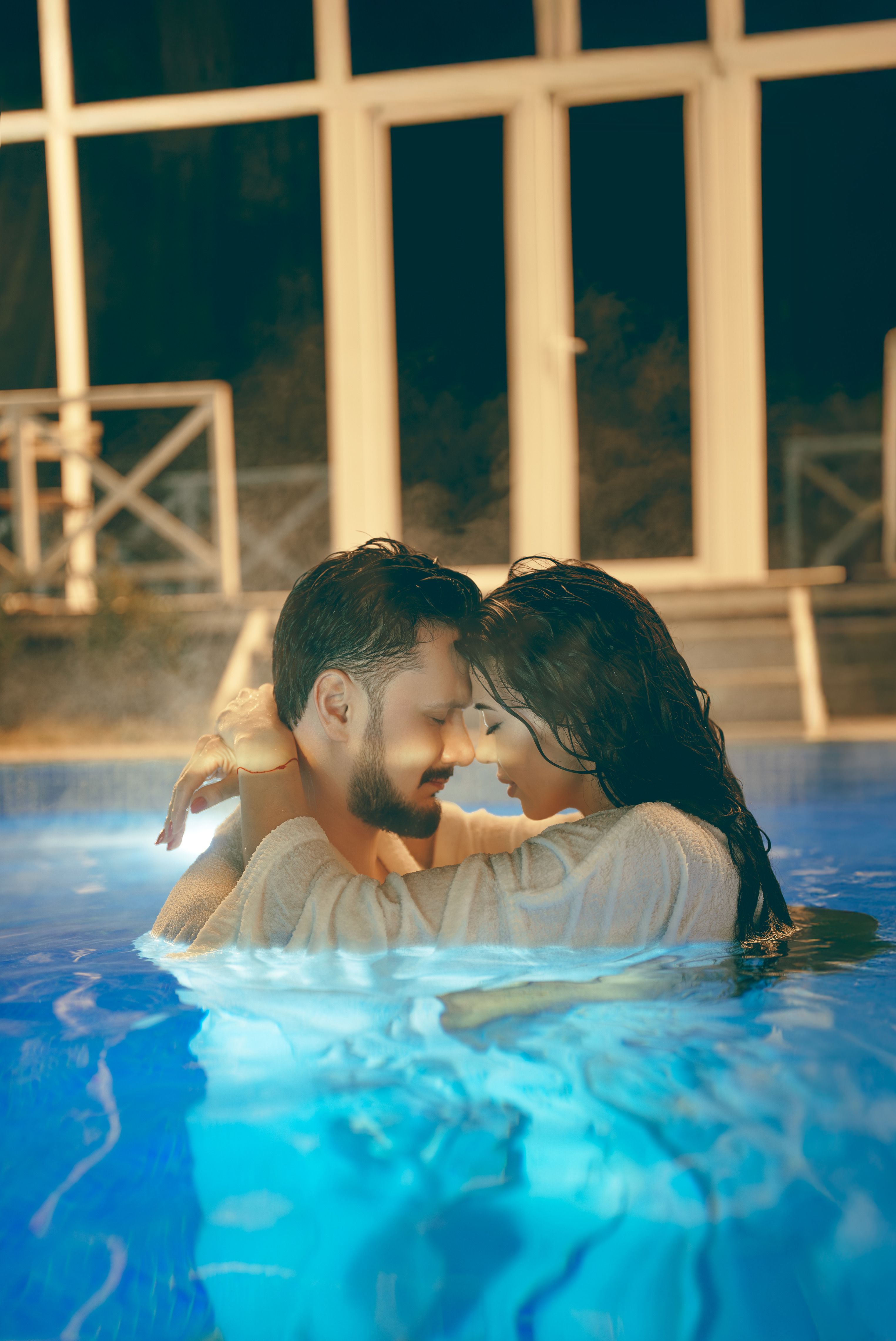 Romantic Evening Embrace in Poolside Glow · Free Stock Photo