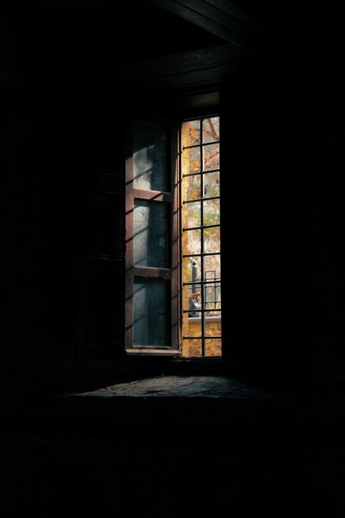 Free A sunlit window in an ancient village house casting soft shadows indoors. Stock Photo