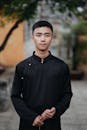 Young Man in Traditional Black Attire Outdoors