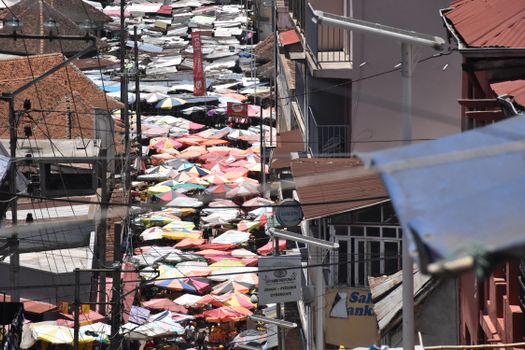 Aerial view of a bustling outdoor market filled with colorful umbrellas and vendors.