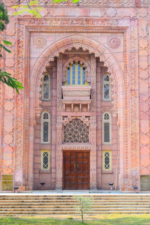 Free Ornate pink stone entrance with intricate carvings and arched design, perfect for architectural themes. Stock Photo