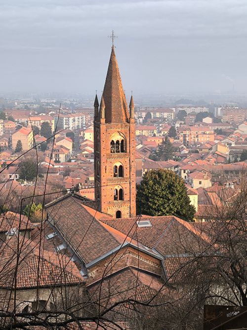 Free Charming aerial view of a historic Italian bell tower and rooftops at dusk. Stock Photo