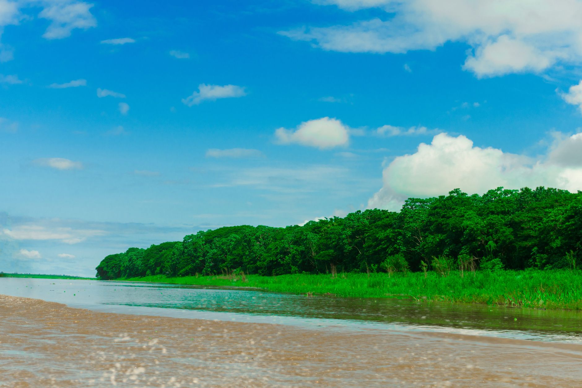 A tranquil scene of the Amazon River and lush greenery in Loreto, Peru.