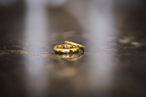 Free Elegant close-up of golden wedding rings on a reflective marble surface, evoking love and commitment. Stock Photo